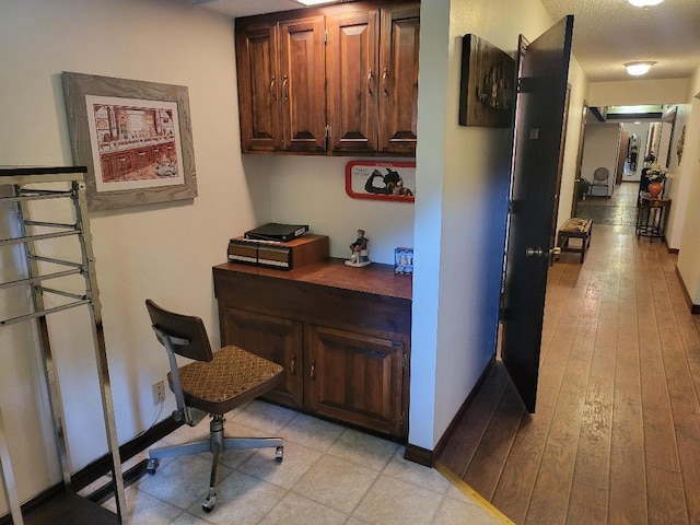 home office featuring a textured ceiling and light hardwood / wood-style flooring