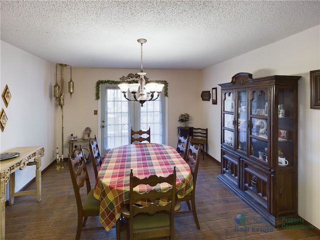 dining space featuring a textured ceiling, dark hardwood / wood-style floors, and an inviting chandelier