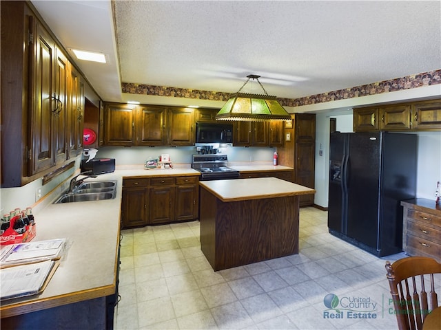 kitchen featuring a kitchen island, sink, black appliances, pendant lighting, and a textured ceiling