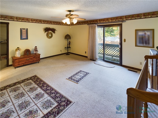 carpeted living room featuring a textured ceiling and ceiling fan