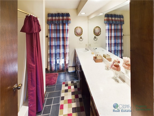 bathroom featuring vanity, shower / tub combo with curtain, and tile patterned flooring