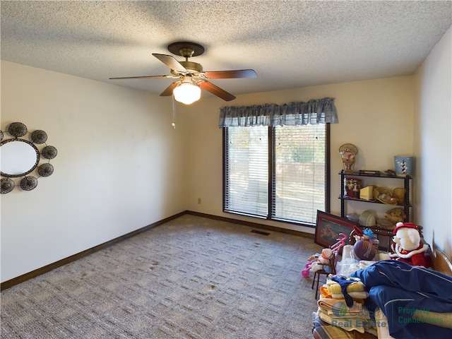 bedroom with a textured ceiling, carpet, and ceiling fan