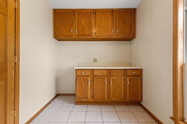 clothes washing area with light tile patterned floors