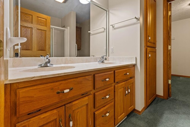 bathroom featuring a textured ceiling, vanity, and walk in shower