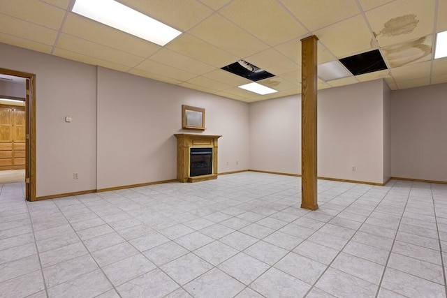 basement with light tile patterned floors and a drop ceiling