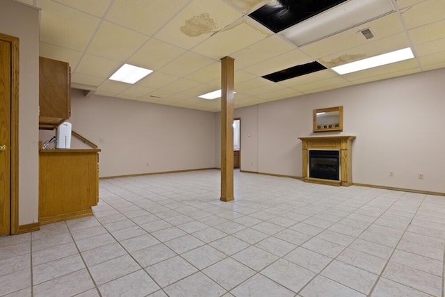 basement with light tile patterned floors and a drop ceiling