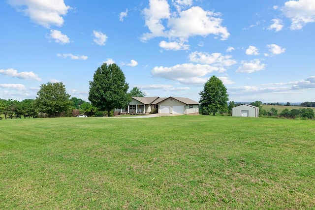 view of yard with a garage and a rural view