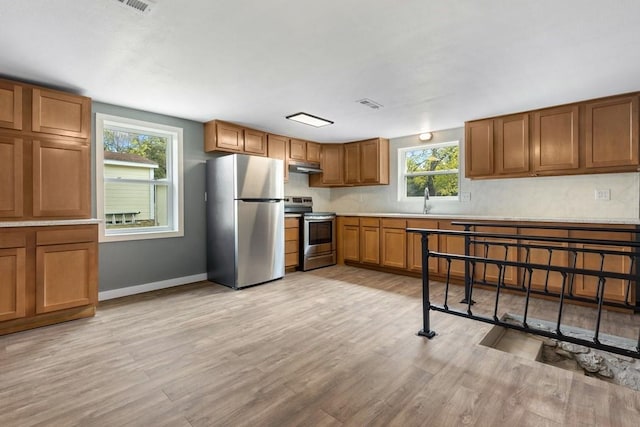 kitchen with light wood-type flooring, stainless steel appliances, and sink