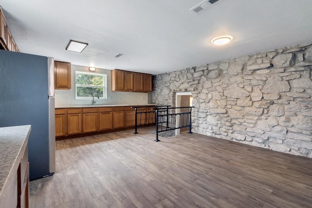 kitchen with sink, light hardwood / wood-style floors, and stainless steel fridge