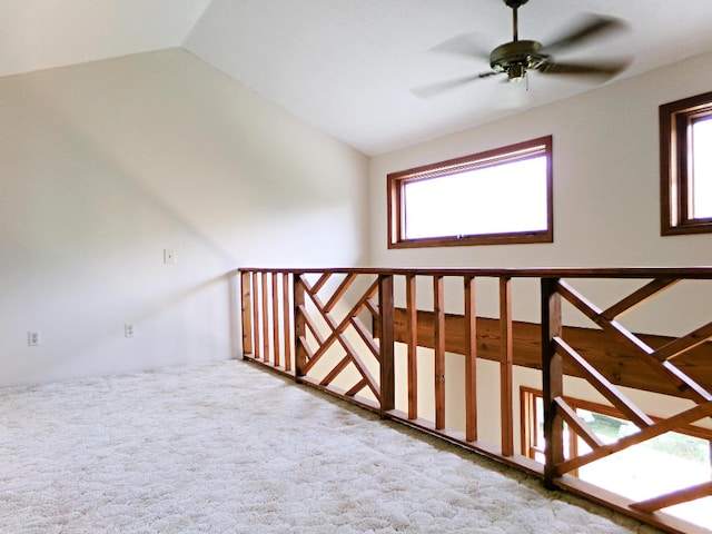 interior space with vaulted ceiling, ceiling fan, and carpet flooring