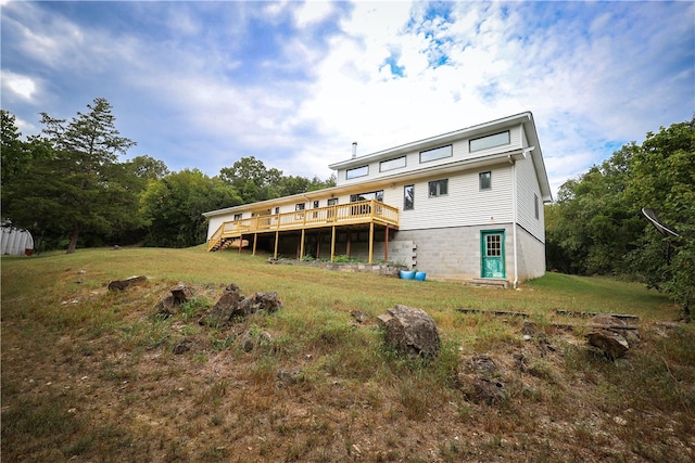 rear view of house with a lawn and a deck