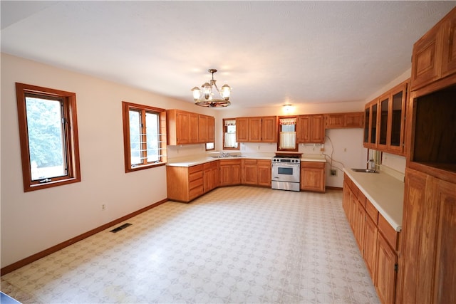 kitchen with an inviting chandelier, decorative light fixtures, sink, and high end stove