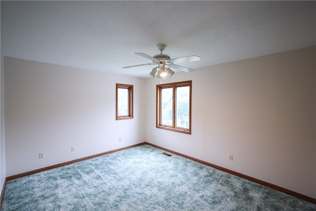 spare room featuring a textured ceiling, ceiling fan, and carpet