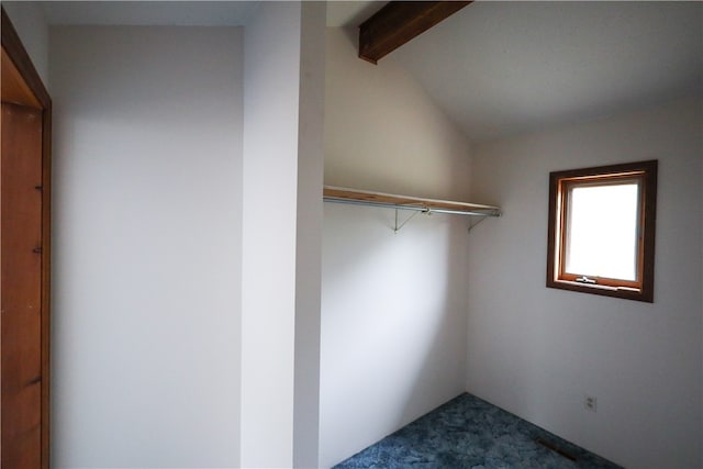 walk in closet featuring lofted ceiling with beams