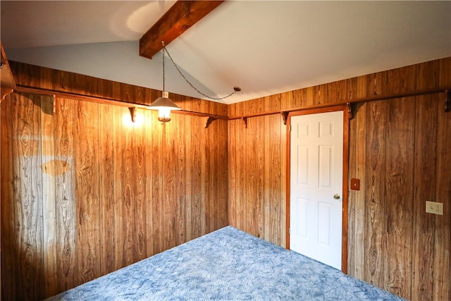 interior space featuring carpet, wooden walls, and vaulted ceiling with beams