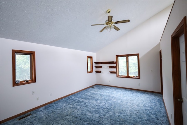 carpeted empty room with a textured ceiling, ceiling fan, and vaulted ceiling