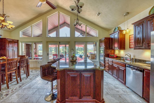 kitchen with a kitchen island, ceiling fan with notable chandelier, dishwasher, sink, and light tile patterned flooring