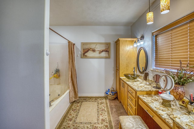 bathroom featuring shower / bath combo with shower curtain, a textured ceiling, and vanity