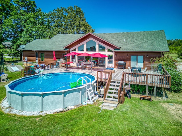 view of pool with a patio area, a deck, and a lawn