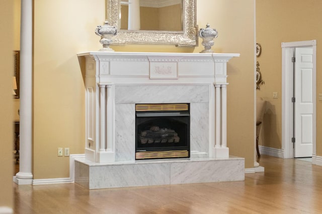 room details featuring baseboards, wood finished floors, and a high end fireplace