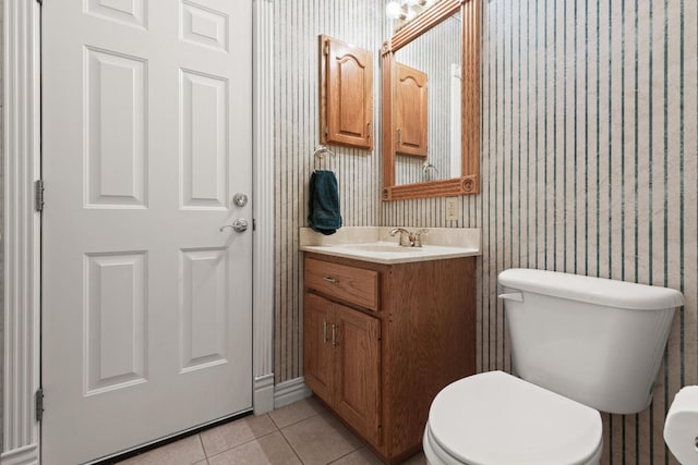 half bathroom featuring wallpapered walls, vanity, toilet, and tile patterned floors