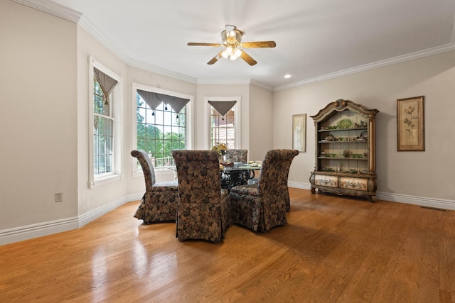 dining room with ornamental molding, light wood finished floors, a ceiling fan, and baseboards