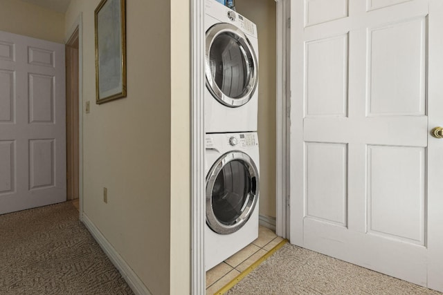 washroom with light tile patterned floors, laundry area, stacked washer / dryer, and light colored carpet