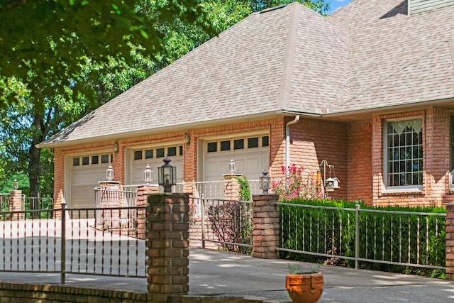 view of front of property with driveway, brick siding, a shingled roof, and fence