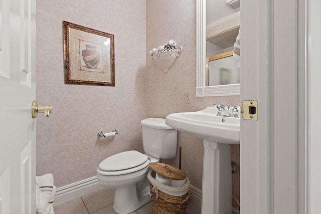 bathroom with a shower with door, toilet, and tile patterned floors