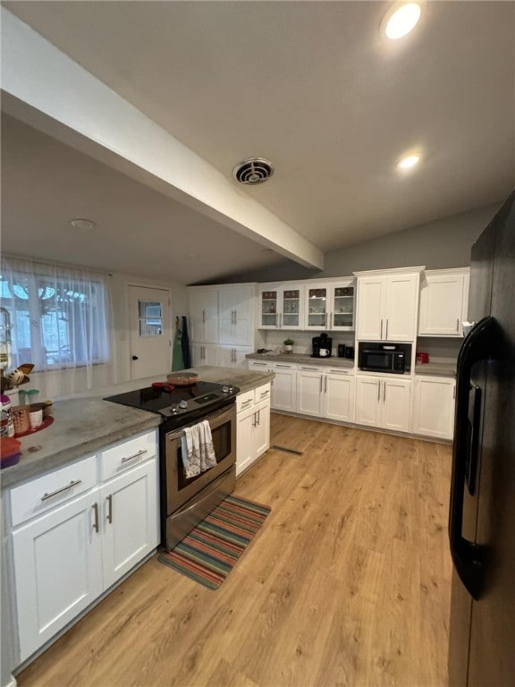 kitchen featuring beam ceiling, electric range, light hardwood / wood-style flooring, and white cabinets