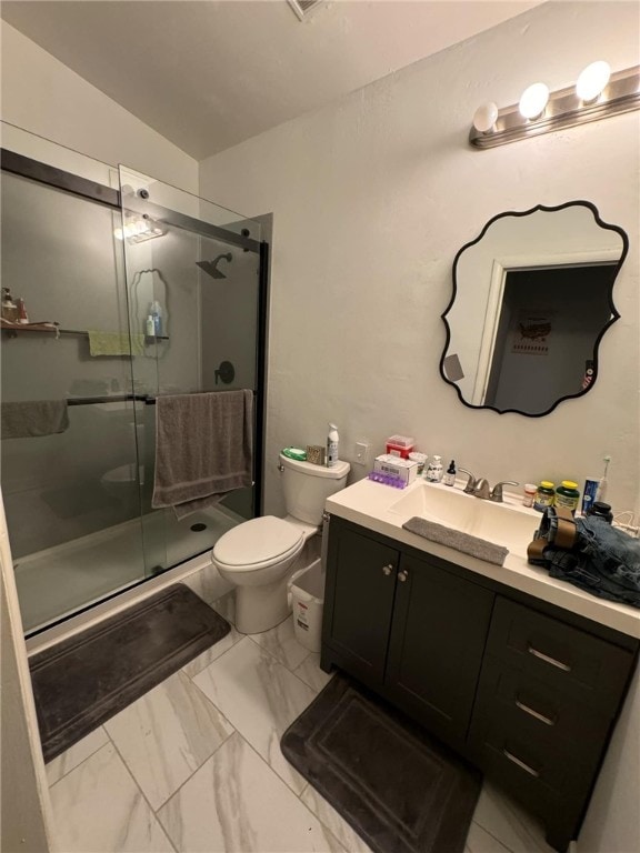 bathroom featuring tile patterned floors, a shower with door, vanity, and toilet