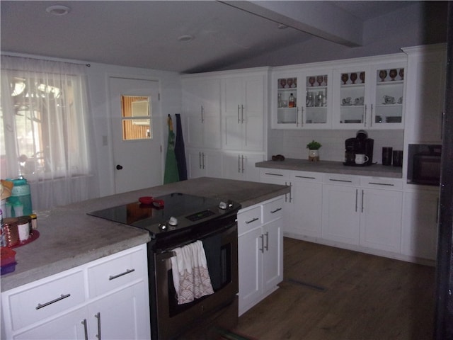 kitchen featuring vaulted ceiling with beams, stainless steel electric stove, white cabinetry, and a healthy amount of sunlight