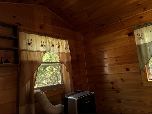 sitting room with vaulted ceiling, plenty of natural light, and wood walls