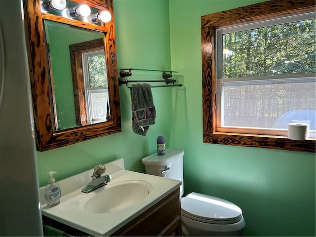 bathroom featuring vanity, toilet, and a healthy amount of sunlight