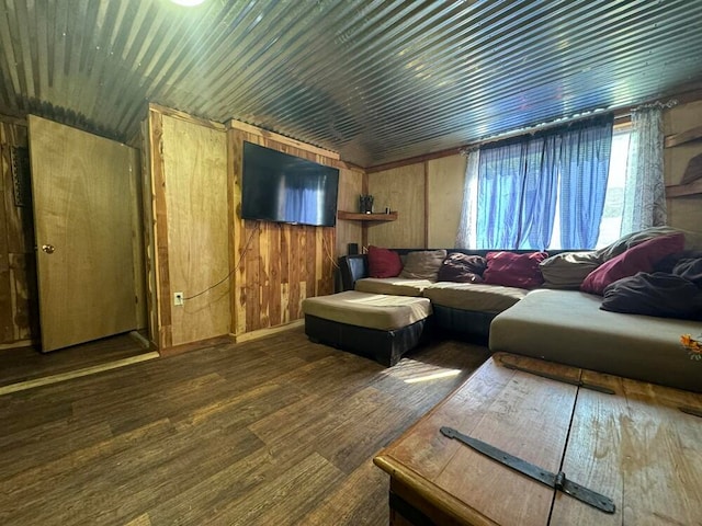 living room with dark hardwood / wood-style floors and wooden walls