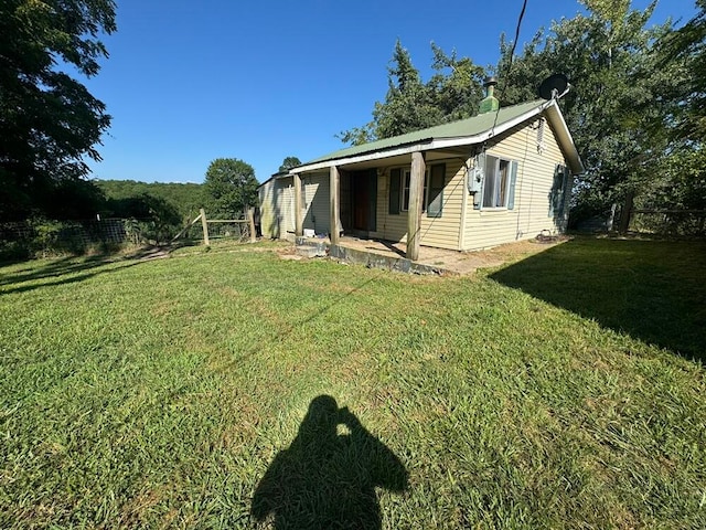 rear view of property featuring a lawn