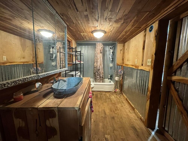 kitchen featuring sink, wooden walls, wooden ceiling, and wood-type flooring