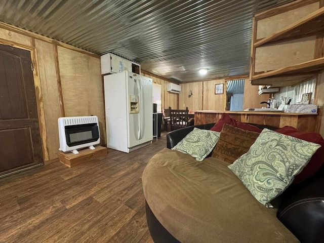 living room with wood walls, heating unit, dark hardwood / wood-style floors, and a wall mounted air conditioner