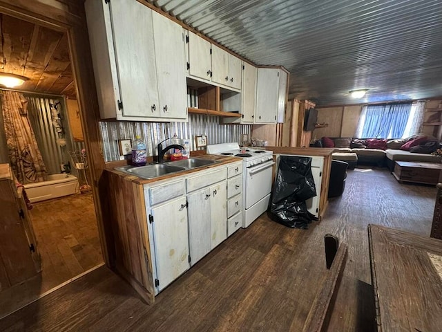 kitchen with white electric stove, dark wood-type flooring, and wooden walls