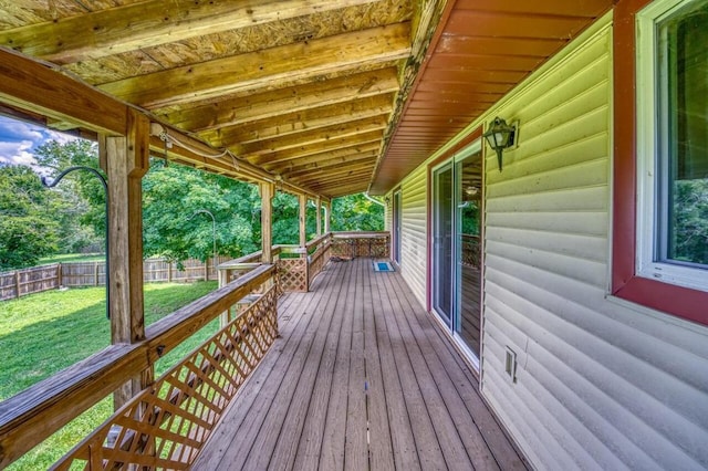 deck with a lawn and fence