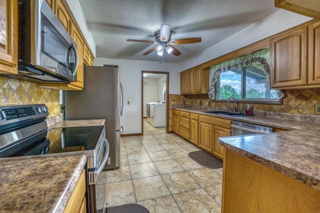 kitchen featuring a sink, dark countertops, a textured ceiling, appliances with stainless steel finishes, and ceiling fan