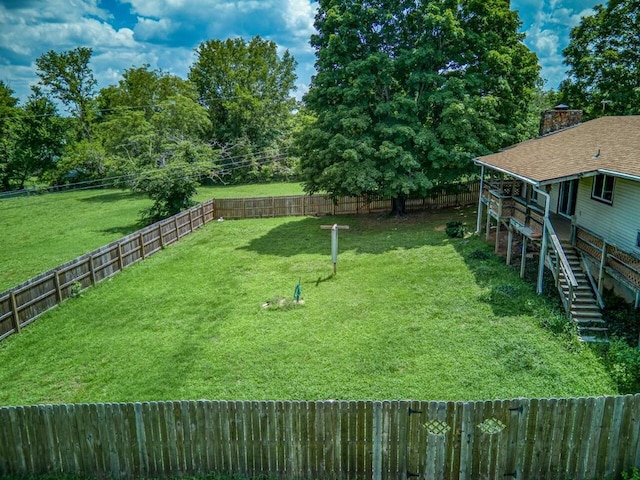 view of yard featuring a fenced backyard and stairs