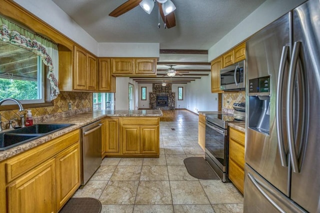 kitchen with backsplash, a peninsula, stainless steel appliances, and a sink