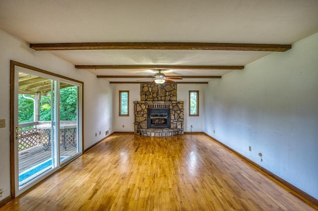 unfurnished living room featuring a fireplace, light wood-type flooring, a wealth of natural light, and baseboards