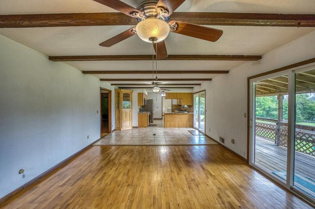 interior space featuring beam ceiling, visible vents, baseboards, and light wood-style floors