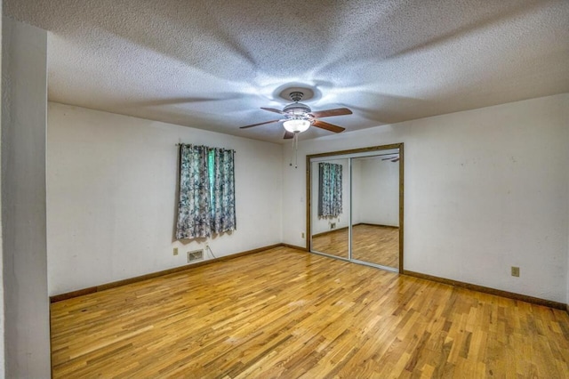 unfurnished bedroom featuring visible vents, ceiling fan, baseboards, and wood finished floors