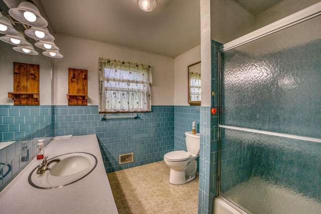 full bath with vanity, tile walls, toilet, and wainscoting