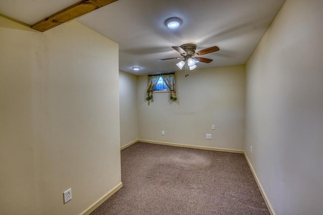 carpeted empty room featuring ceiling fan and baseboards