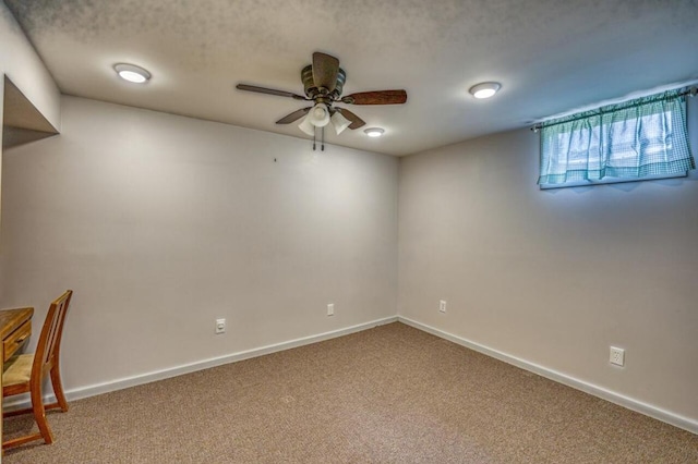 below grade area with a textured ceiling, a ceiling fan, baseboards, and carpet floors