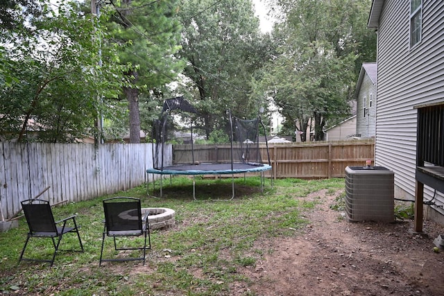 view of yard featuring a trampoline and central AC unit